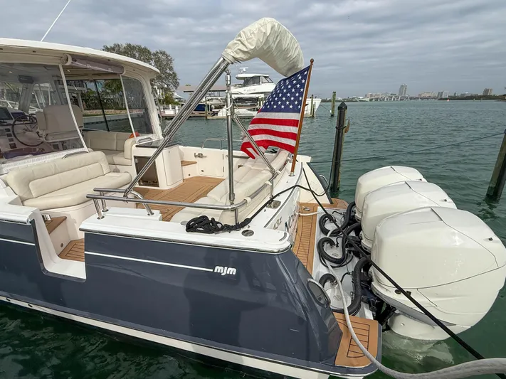 Noble Grace Yacht Photos Pics 2019 MJM 43z boat with American flag, docked, featuring triple outboard engines.