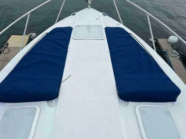 Attitude Is Everything Yacht Photos Pics 2007 Formula 31 PC boat deck with blue cushions, docked by the water.