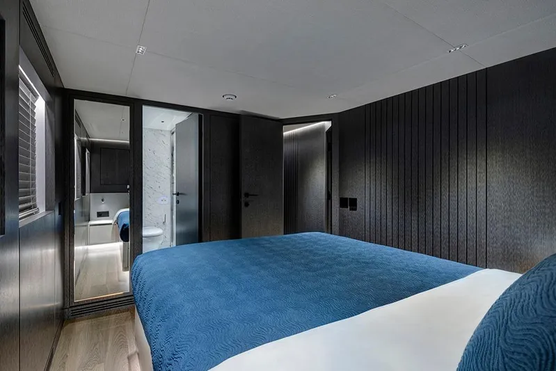  Yacht Photos Pics Luxurious bedroom interior on 1988 Heesen 32 yacht, featuring modern design and blue bedding.