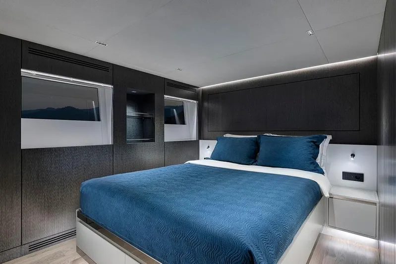  Yacht Photos Pics Luxurious bedroom interior on 1988 Heesen 32 yacht, featuring modern design and blue bedding.