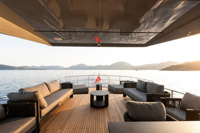  Yacht Photos Pics Luxurious 1988 Heesen 32 yacht deck with elegant seating, overlooking serene waters and mountains.