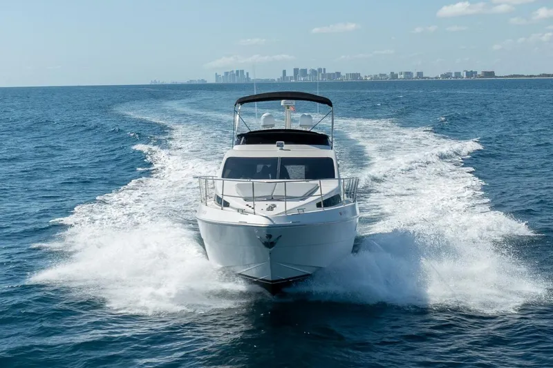  Yacht Photos Pics 2001 Azimut 46 yacht cruising on open sea with city skyline in background.