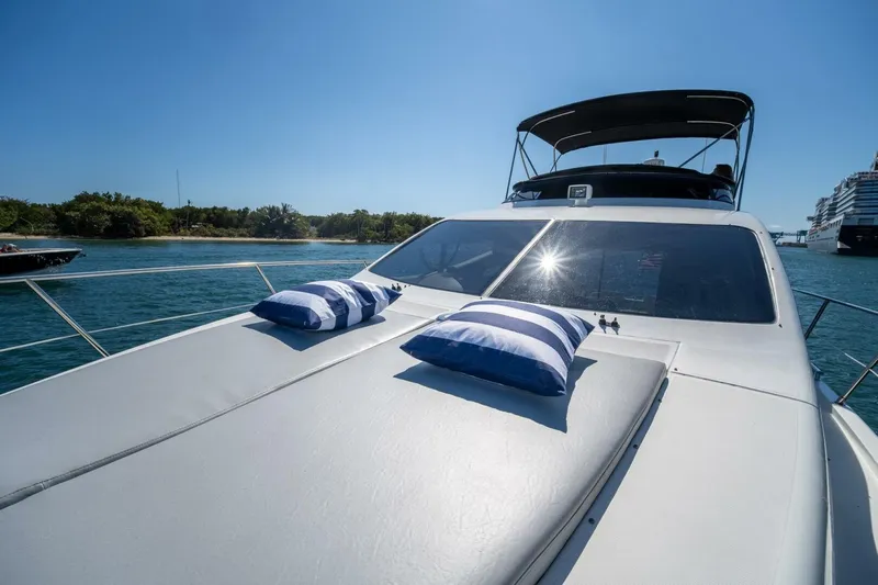  Yacht Photos Pics Luxury Azimut 46 yacht from 2001 with sunbathing deck and striped cushions on open water.