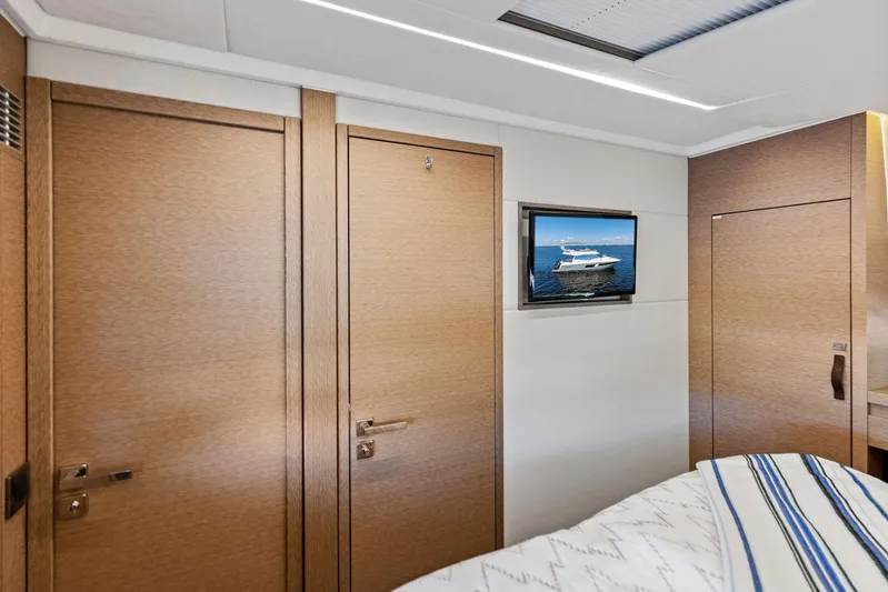  Yacht Photos Pics Interior of 2018 Prestige 460 yacht cabin with TV and wooden doors.