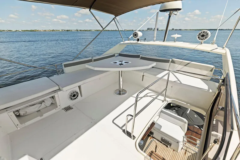  Yacht Photos Pics 2018 Prestige 460 yacht deck with seating and table, overlooking calm waters.
