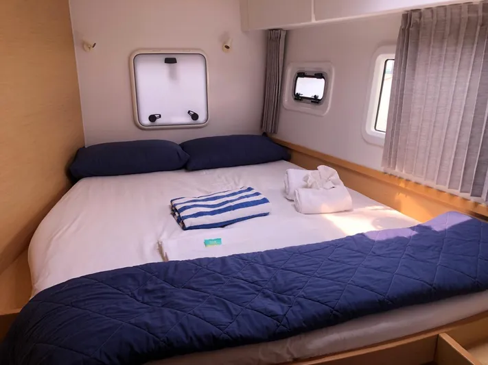 Darwin Yacht Photos Pics Cozy bedroom in 2020 Lagoon 42 catamaran with neatly arranged bed and windows.