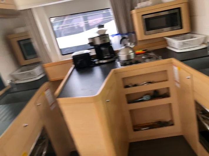 Darwin Yacht Photos Pics Modern kitchen area inside a 2020 Lagoon 42 catamaran, featuring appliances and ample counter space.