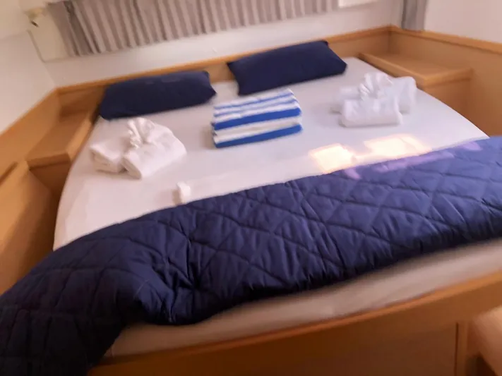 Darwin Yacht Photos Pics Cozy bedroom in a 2020 Lagoon 42 catamaran with neatly arranged towels and bedding.