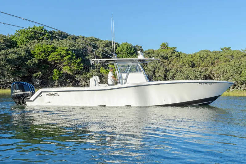  Yacht Photos Pics 2015 Invincible 39 Open Fisherman boat on calm water, surrounded by lush greenery.