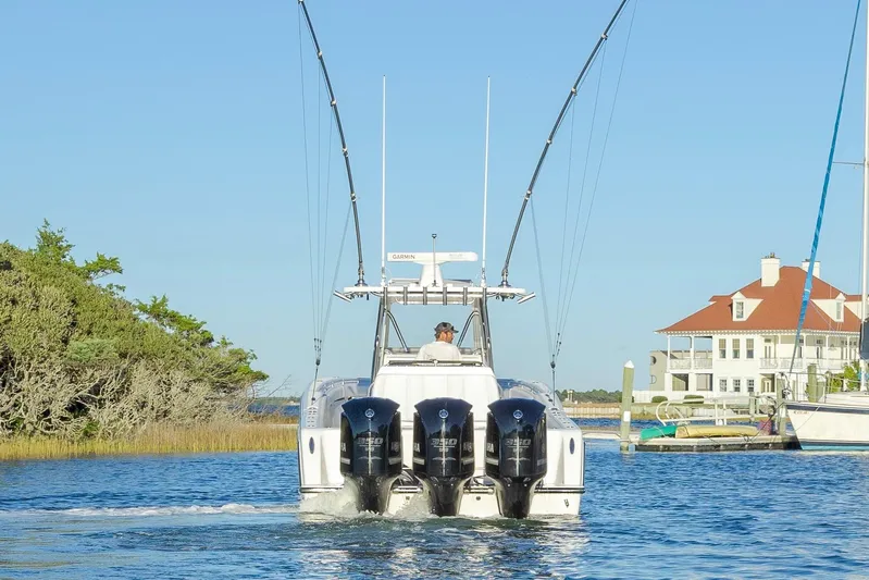  Yacht Photos Pics 2015 Invincible 39 Open Fisherman boat cruising near waterfront homes.