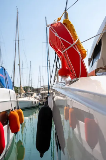  Yacht Photos Pics 2023 Fountaine Pajot Isla 40 catamaran docked, featuring safety equipment and colorful fenders.