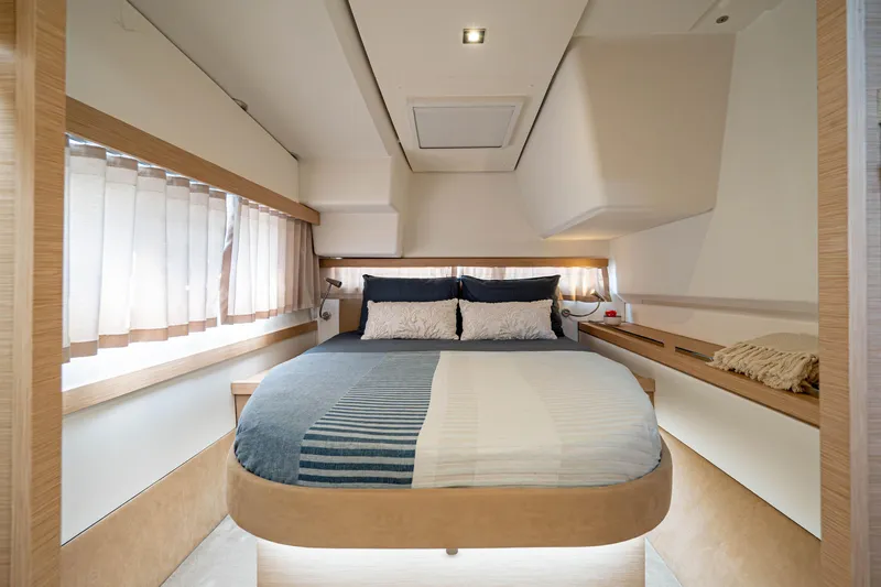  Yacht Photos Pics Luxurious bedroom interior of 2023 Fountaine Pajot Isla 40 catamaran, featuring modern design and cozy bedding.