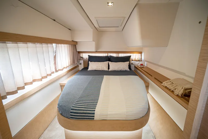  Yacht Photos Pics Luxurious bedroom interior of 2023 Fountaine Pajot Isla 40 catamaran, featuring modern design and cozy bedding.