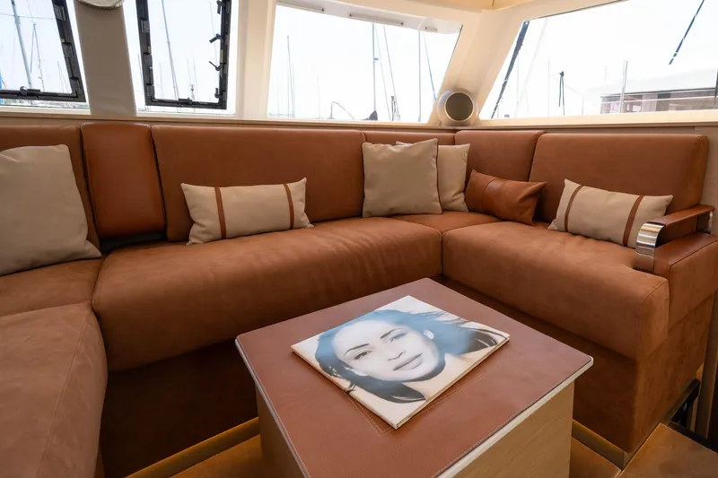  Yacht Photos Pics Luxurious interior of 2023 Fountaine Pajot Isla 40 catamaran with plush seating and decorative pillows.