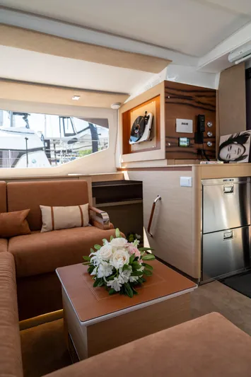  Yacht Photos Pics Luxurious interior of 2023 Fountaine Pajot Isla 40 catamaran with elegant seating and floral centerpiece.