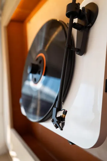  Yacht Photos Pics Close-up of a modern turntable with a vinyl record playing.