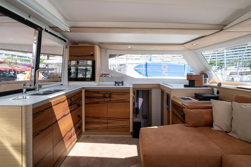  Yacht Photos Pics Luxurious interior of 2023 Fountaine Pajot Isla 40 catamaran with modern kitchen and seating area.
