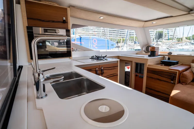  Yacht Photos Pics Modern kitchen interior of 2023 Fountaine Pajot Isla 40 catamaran, featuring sleek design and appliances.