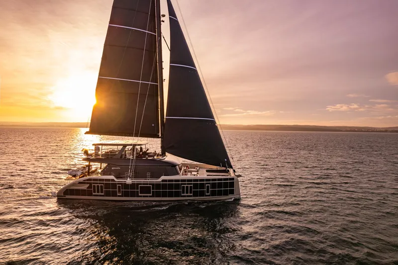 Otoctone Yacht Photos Pics 2024 Sunreef 80 sailing yacht at sunset on open sea.