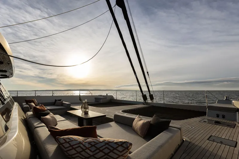 Otoctone Yacht Photos Pics Luxurious Sunreef 80 sailing yacht deck at sunset, 2024 model, with elegant seating and ocean view.