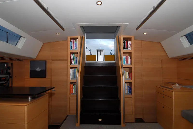 Whimsy Yacht Photos Pics Luxurious interior of 2005 Vaudrey Miller 78 yacht with wooden cabinetry and bookshelves.