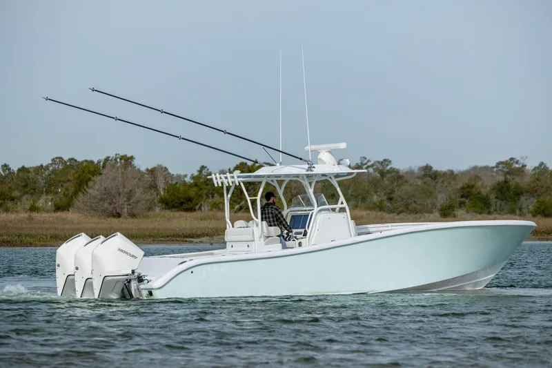  Yacht Photos Pics 2025 Yellowfin 34 Offshore boat cruising on water with triple Mercury engines.
