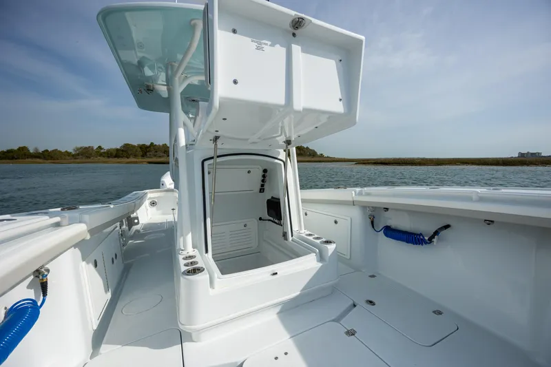  Yacht Photos Pics 2025 Yellowfin 34 Offshore boat interior with open storage compartment, docked on calm water.