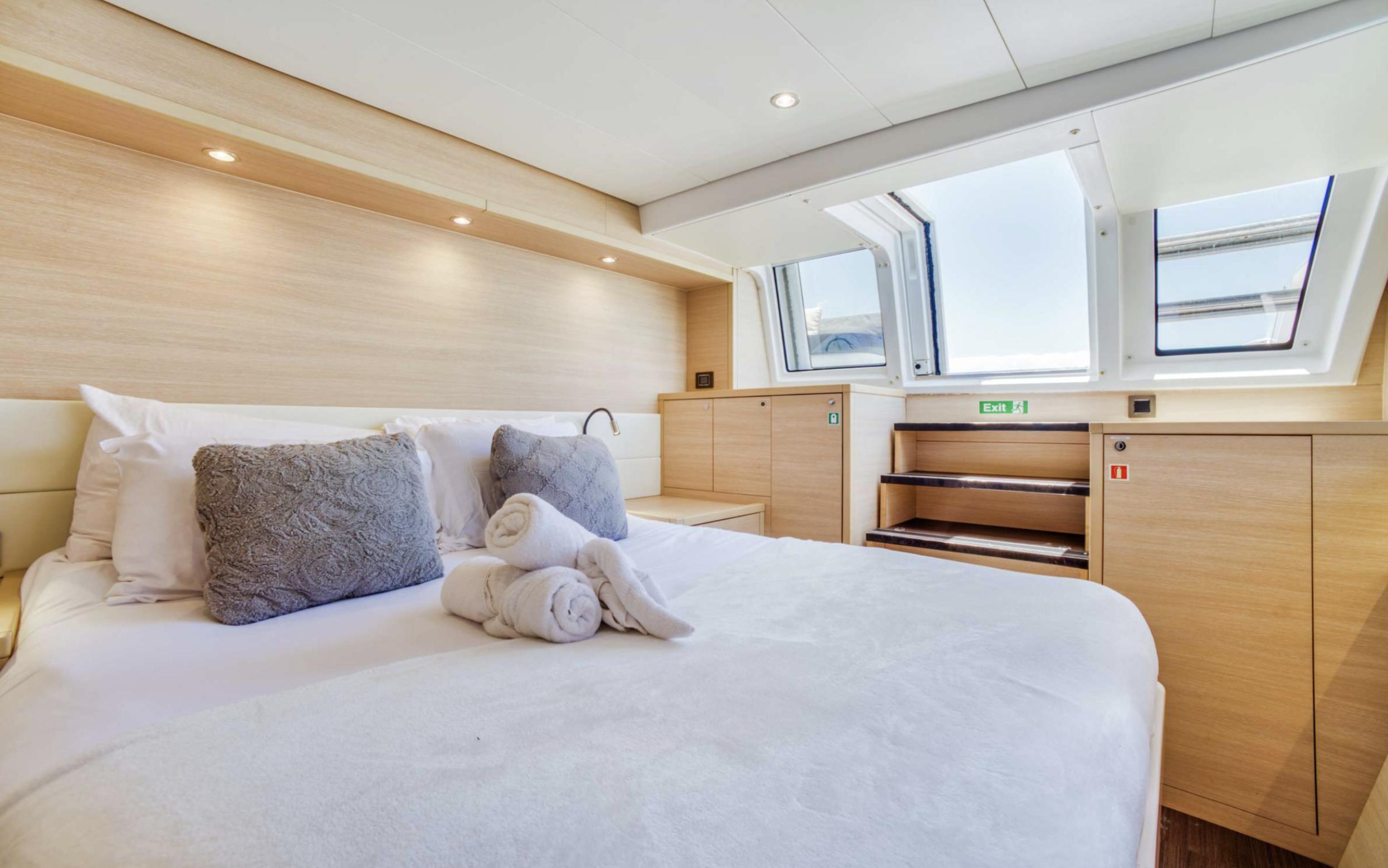 Luxurious bedroom interior of 2020 Lagoon 620 yacht with skylight and modern decor.