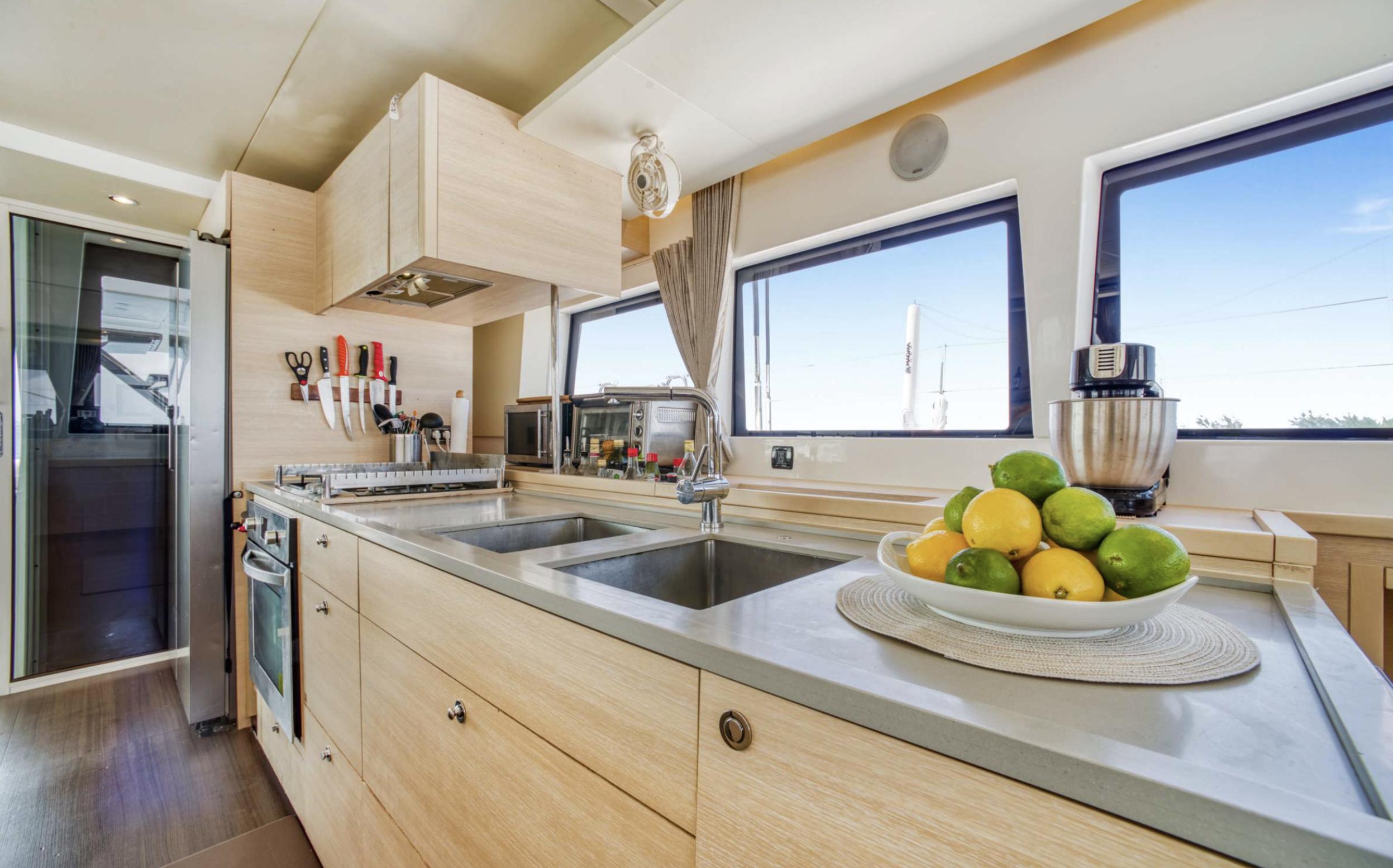 Modern kitchen interior on 2020 Lagoon 620 yacht with sleek design and ample natural light.