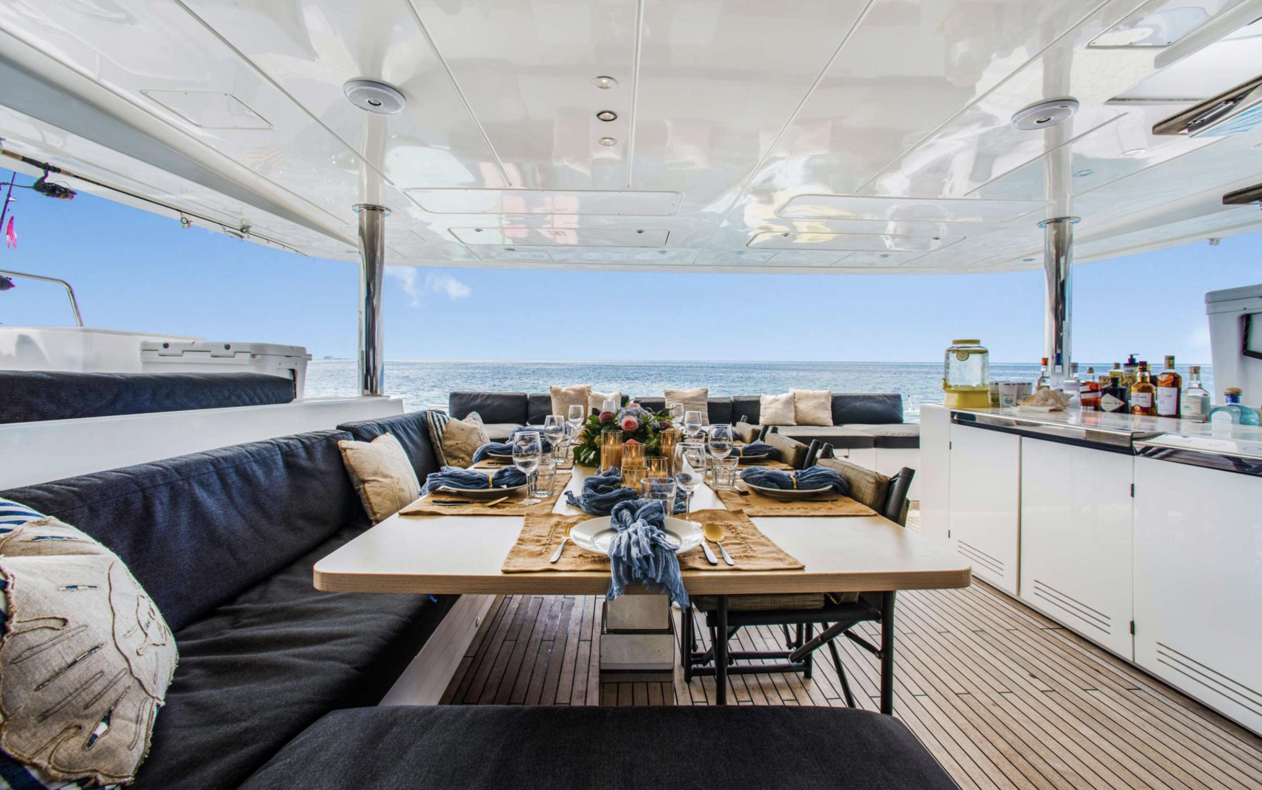Luxurious Lagoon 620 yacht dining area with elegant table setting, ocean view, and modern amenities.