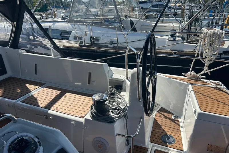 Yours To Name Yacht Photos Pics Cockpit of 2026 Jeanneau 440 Sun Odyssey sailboat with wooden deck and steering wheel.