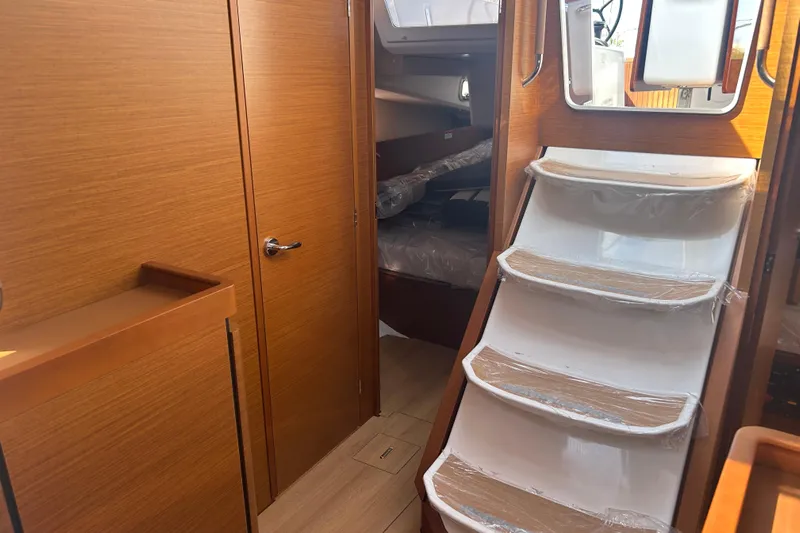 Yours To Name Yacht Photos Pics Interior of 2026 Jeanneau 440 Sun Odyssey yacht with wooden finish and stairs.