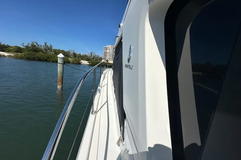 Mer Sea Yacht Photos Pics 2021 Beneteau Swift Trawler 41 Fly cruising near shoreline, clear blue sky.