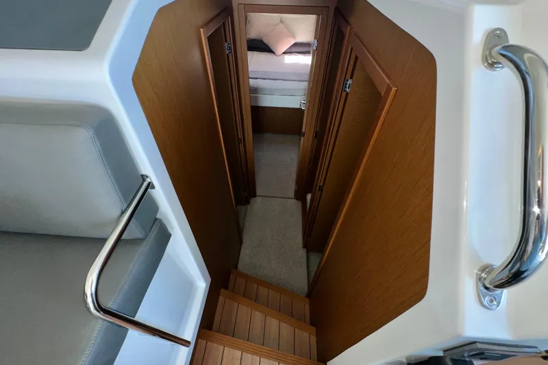Mer Sea Yacht Photos Pics Interior view of 2021 Beneteau Swift Trawler 41 Fly, featuring wooden stairs and cozy cabin.