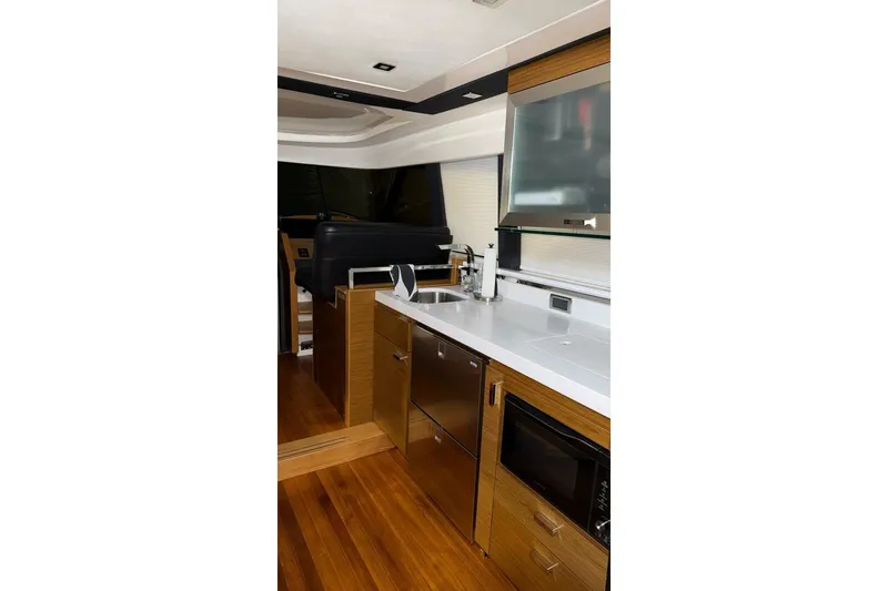 Strange Magic II Yacht Photos Pics Interior of 2018 Tiara Yachts C44 Coupe, featuring modern kitchen with wood accents.