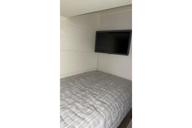 Strange Magic II Yacht Photos Pics Interior cabin of 2018 Tiara Yachts C44 Coupe with bed and wall-mounted TV.