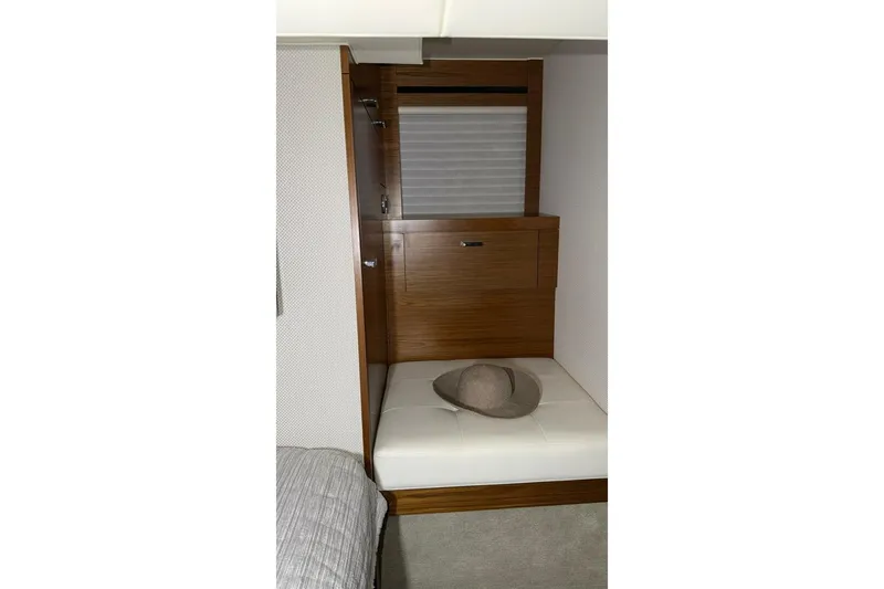 Strange Magic II Yacht Photos Pics Interior cabin of 2018 Tiara Yachts C44 Coupe with wooden cabinetry and cushioned seating.