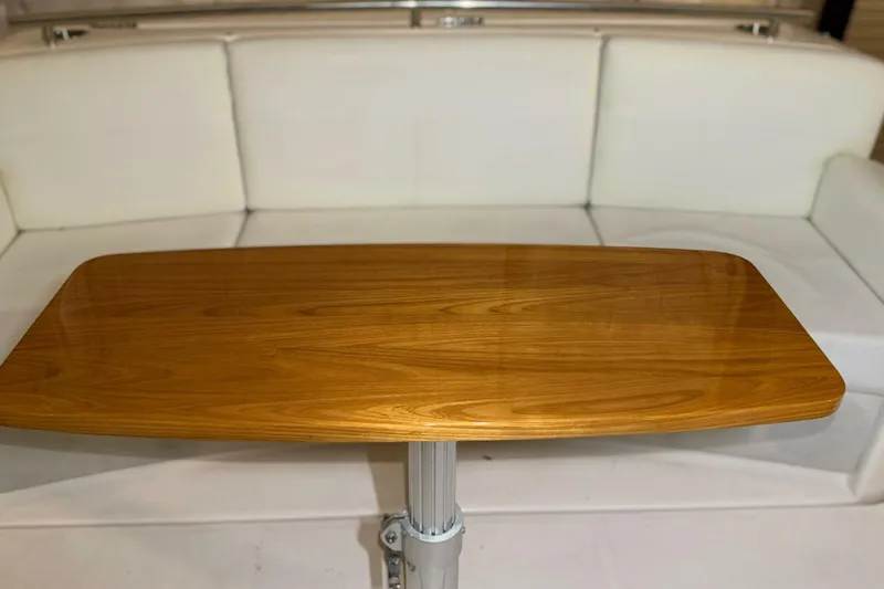 Strange Magic II Yacht Photos Pics Wooden table on 2018 Tiara Yachts C44 Coupe, with white seating background.