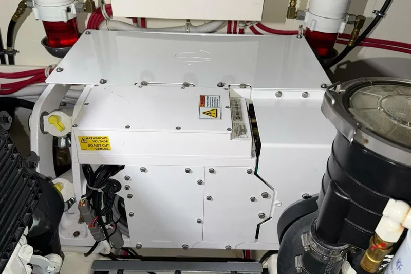 Strange Magic II Yacht Photos Pics Engine room of 2018 Tiara Yachts C44 Coupe with electrical components and warning labels.