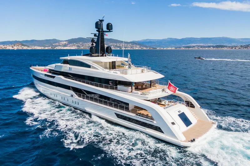 Rio Yacht Photos Pics Luxurious 2022 CRN 62m yacht cruising on open sea with scenic coastal backdrop.