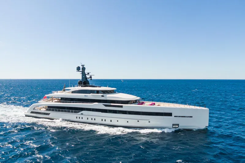 Rio Yacht Photos Pics Luxurious 2022 CRN 62m yacht cruising on open sea under clear blue sky.