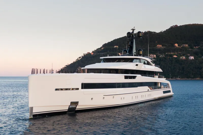 Rio Yacht Photos Pics Luxurious 2022 CRN 62m yacht cruising near scenic coastline at sunset.