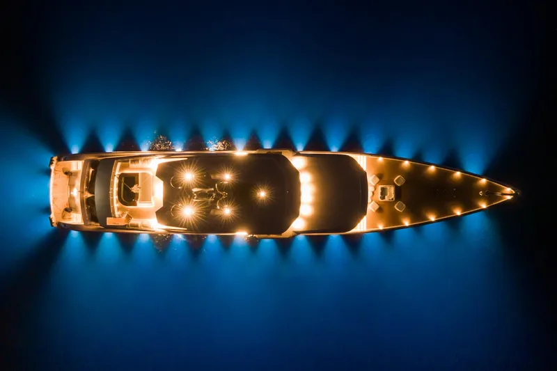 Rio Yacht Photos Pics Aerial view of illuminated 2022 CRN 62m yacht on dark water at night.