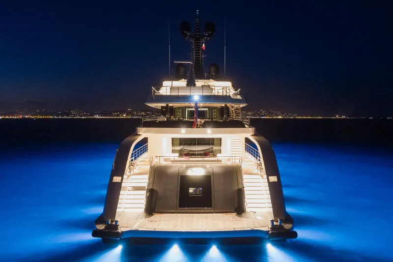 Rio Yacht Photos Pics Luxurious 2022 CRN 62m yacht illuminated at night on calm waters.