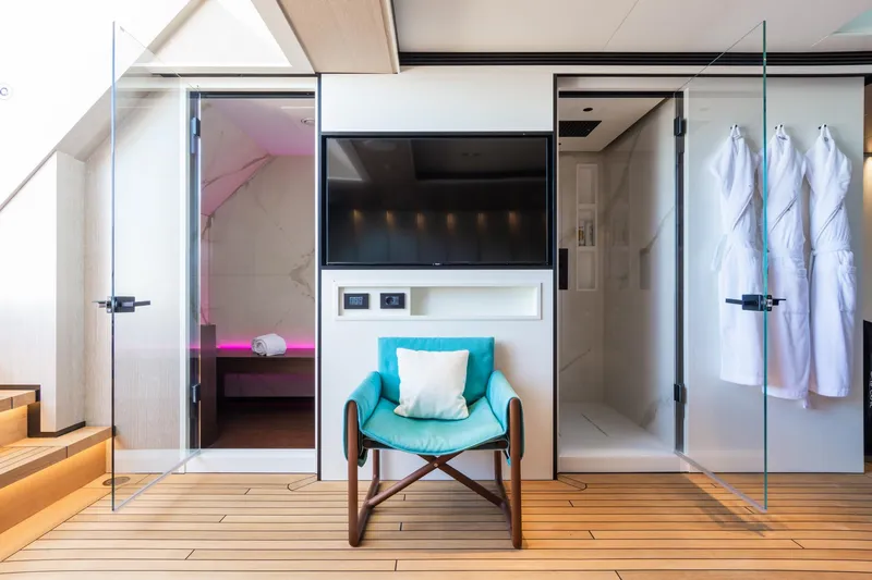 Rio Yacht Photos Pics Luxurious CRN 62m yacht interior, featuring a modern lounge with a TV, chair, and robes.