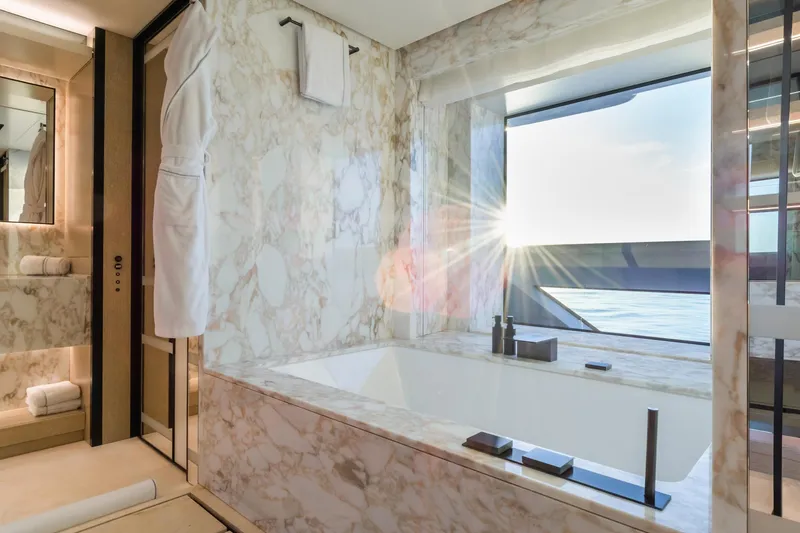 Rio Yacht Photos Pics Luxurious marble bathroom on CRN 62m yacht, 2022, with ocean view and sunlight streaming in.