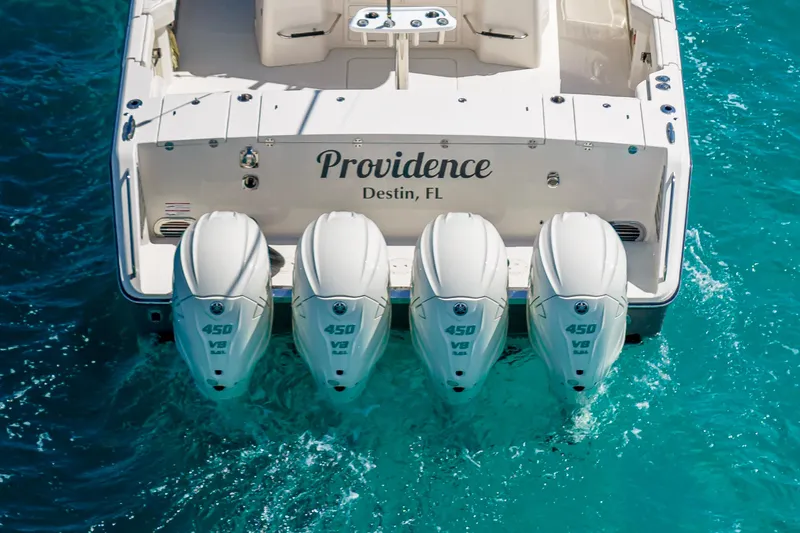  Yacht Photos Pics 2025 Grady-White Canyon 456 boat with four powerful outboard engines in turquoise water.