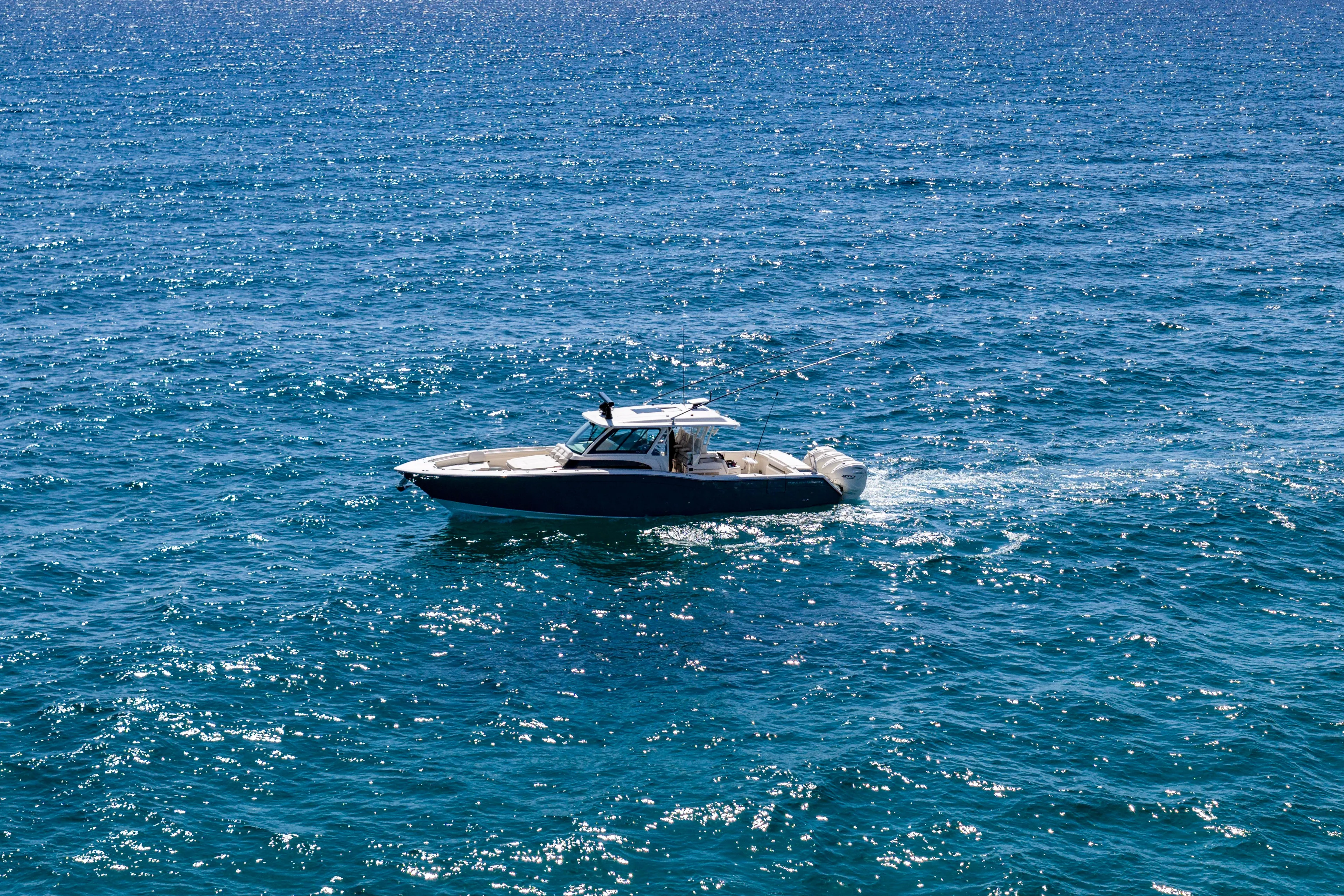  Yacht Photos Pics 2025 Grady-White Canyon 456 boat cruising on sparkling blue ocean waters.