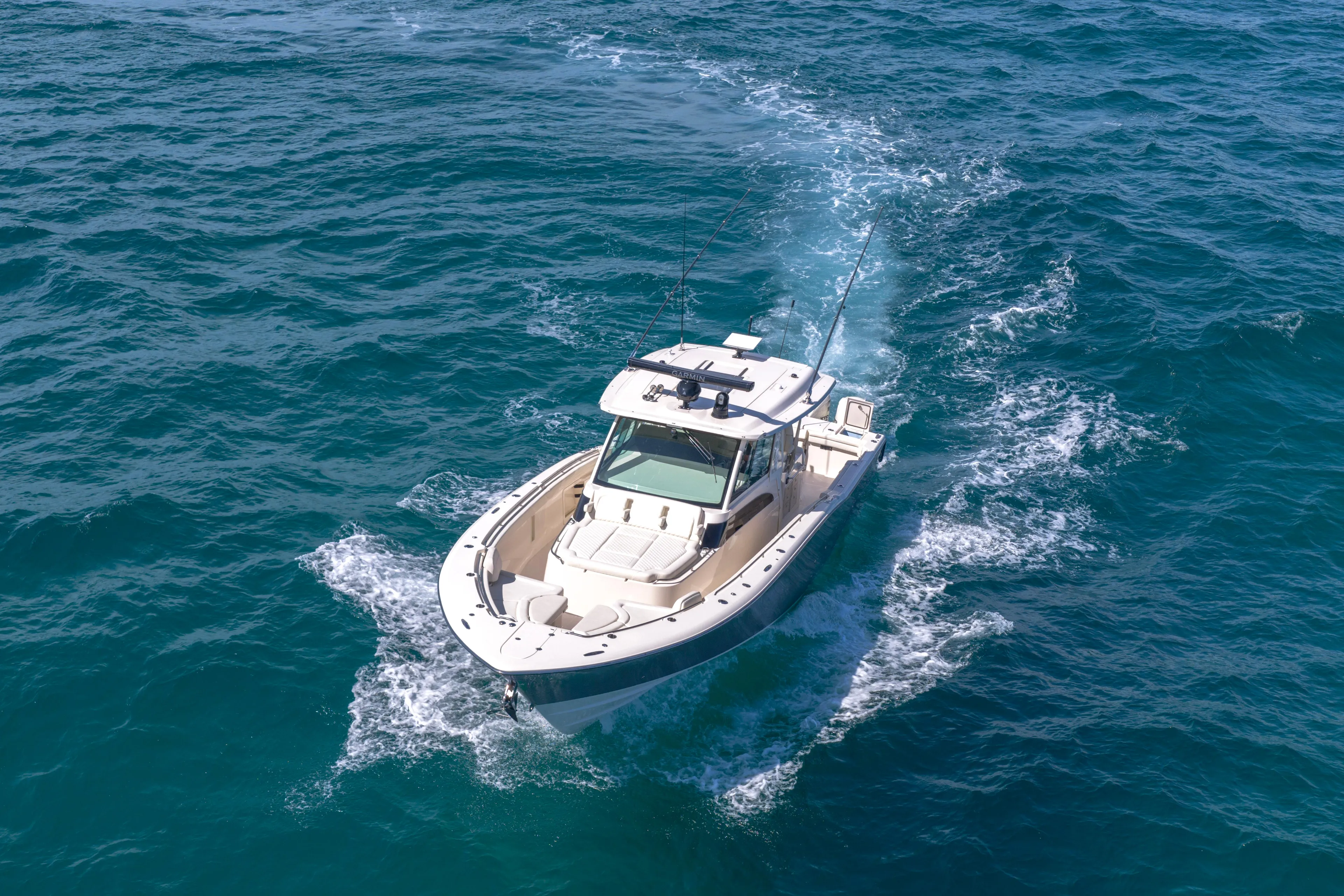  Yacht Photos Pics 2025 Grady-White Canyon 456 boat cruising on open blue ocean waters.