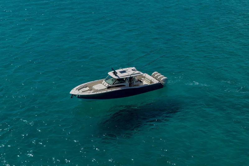  Yacht Photos Pics 2025 Grady-White Canyon 456 boat cruising on clear blue ocean waters.